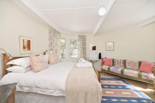 sypialnia z dużym łóżkiem i kanapą w obiekcie Cliff Cottage In Arniston w mieście Arniston