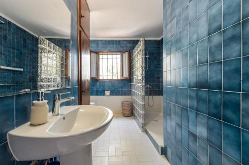 a bathroom with a sink and blue tiled walls at Ca Nostra Ibiza in Port des Torrent