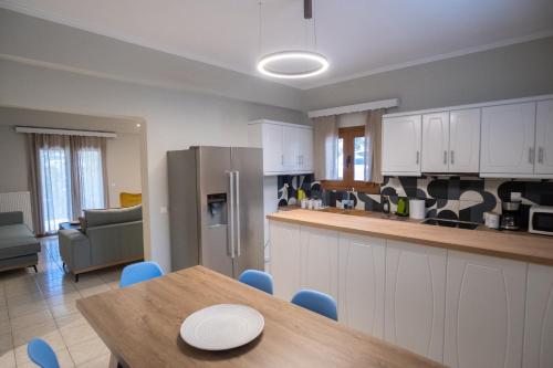 a kitchen with white cabinets and a wooden table with a dining room at Coral Apartments in Parga