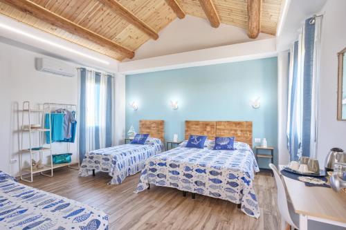 a bedroom with two beds and a wooden ceiling at LANTERNA DEL DELTA Guest House in Porto Tolle