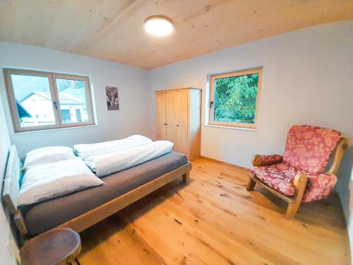 um quarto com uma cama e uma cadeira em Barbilihof em Raggal