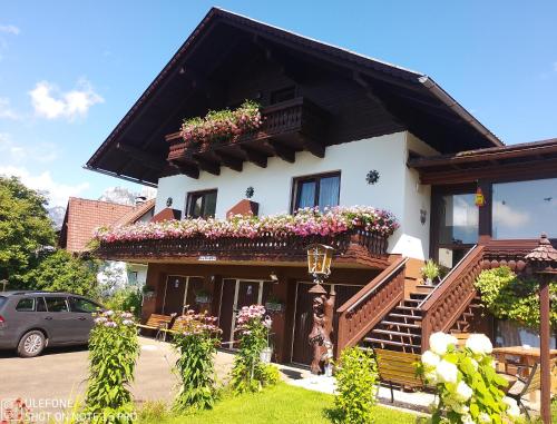 a house with flowers on the balconies of it at Haus Bergblick am Grünen See in Oberort