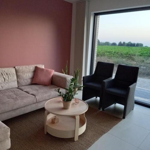 a living room with a couch and two chairs at De Molenlos in Zottegem