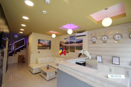 a lobby with a waiting room with clocks on the wall at Pensiunea President City in Roşiori de Vede