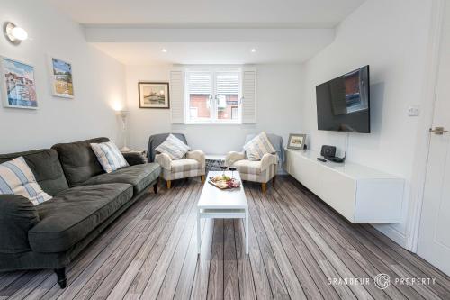 un soggiorno con un divano e una TV di The Herons Nest by Grandeur Property a Lymington