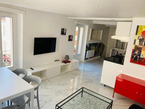 a living room with a tv on a white wall at NEW TOP DUPLEX CENTRE AVEC TERRASSE ET PARKING in Clermont-Ferrand