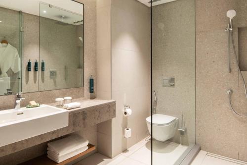 a bathroom with a sink and a toilet and a shower at Hilton Mauritius Resort & Spa in Flic-en-Flac