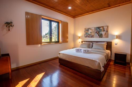 a bedroom with a large bed and a window at Quinta das Mirandas Nature in Oliveira de Frades