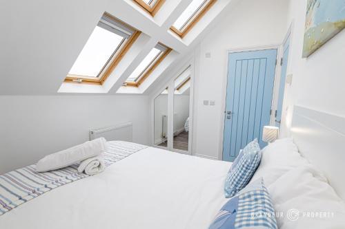 um quarto branco com clarabóias e uma cama em Tranquil 3-Bedroom Haven in Lymington - The Herons Nest em Lymington