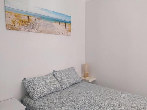 een slaapkamer met een bed en een foto van een strand bij Casa Belice in Vila Real de Santo António