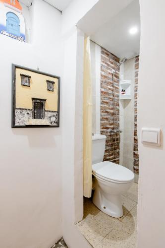 a bathroom with a toilet and a painting on the wall at Studio Tnaker in Tangier