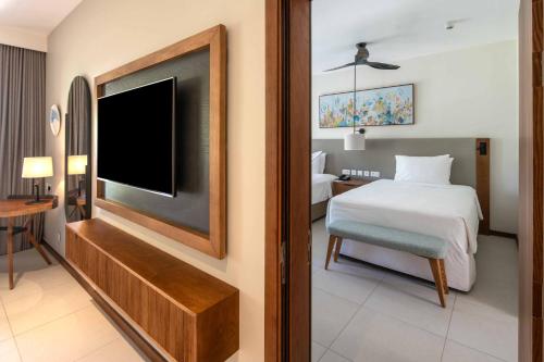 a hotel room with a bed and a tv at Hilton Mauritius Resort & Spa in Flic-en-Flac