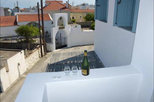a bottle of wine sitting on a table with two glasses at Villa Polixeni Gennadi in Gennadi
