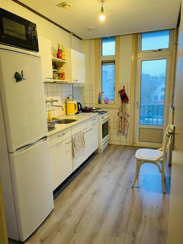 uma cozinha com um frigorífico, uma mesa e uma cadeira em Best located flat in Saint-Germain-des-Prés em Paris