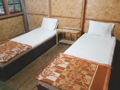 a room with two beds and a table with a bed sidx sidx sidx at Angel's Homestay Batutumonga in Rantepao