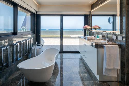 Łazienka z wanną i widokiem na ocean w obiekcie Cala Beach Resort w mieście Punta Ala