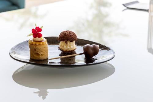 three desserts on a plate on a table at Cala Beach Resort in Punta Ala