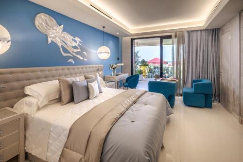 sypialnia z dużym łóżkiem i niebieskimi ścianami w obiekcie Cala Beach Resort w mieście Punta Ala