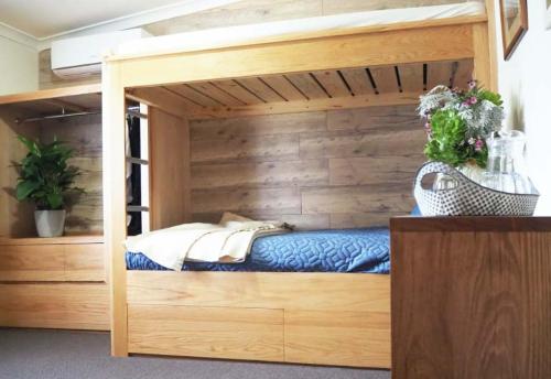 Łóżko piętrowe w pokoju z drewnianą ścianą w obiekcie Buckley's Hope Estate 