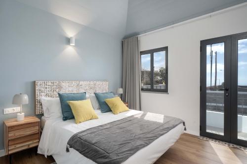 um quarto com uma cama grande com almofadas azuis e amarelas em OurMadeira-Villa Loreto em Arco da Calheta