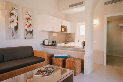 ein Wohnzimmer mit einem Sofa und einer Küche in der Unterkunft Maspalomas Resort by Dunas in Maspalomas