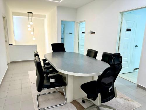 a conference room with a table and black chairs at Three Homestay in Perai