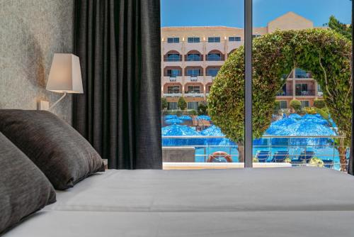 a bedroom with a bed with a view of a building at Mirador Maspalomas by Dunas in Maspalomas