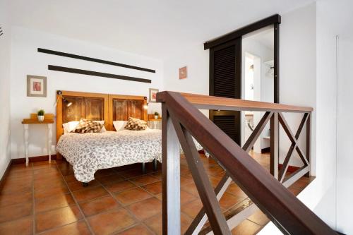 een slaapkamer met een bed met een houten hoofdeinde bij Finca Emblemática - Nº3 Liria in La Vegueta
