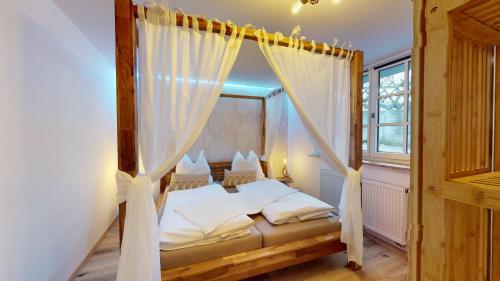 um quarto com uma cama de dossel e uma janela em Hufschmieds Bleibe em Passau