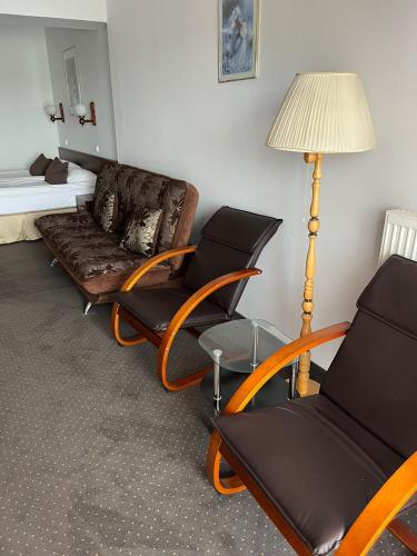 a room with a couch and chairs and a lamp at Eva in Mrągowo
