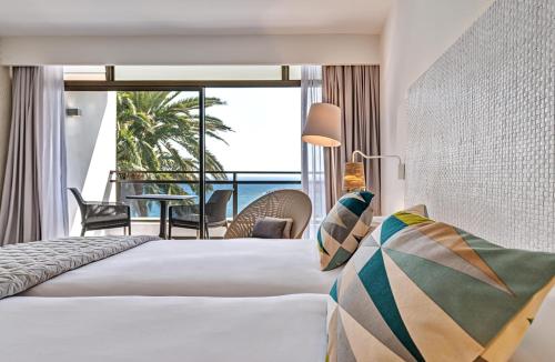 a hotel room with a bed and a view of the ocean at Don Gregory by Dunas - Adults Only in San Agustin