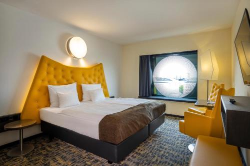 um quarto de hotel com uma cama grande e uma janela em ARCOTEL Onyx Hamburg em Hamburgo