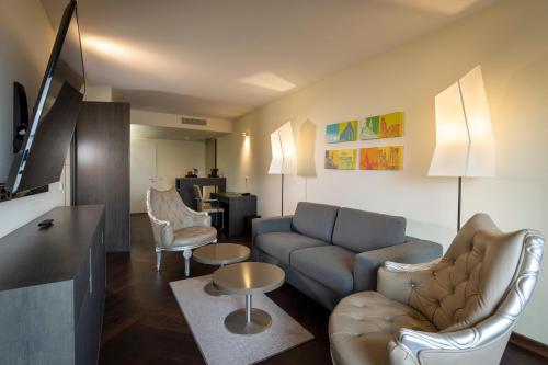 a living room with a couch and chairs and a table at ARCOTEL Onyx Hamburg in Hamburg
