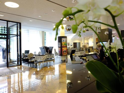 een lobby met een vrouw aan een bureau bij ARCOTEL Onyx Hamburg in Hamburg