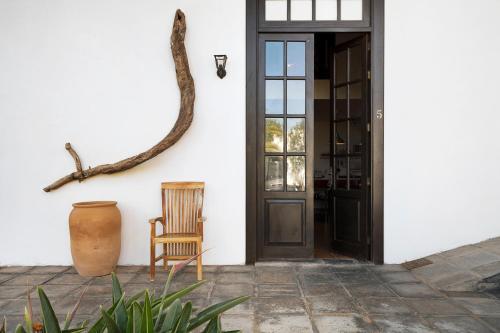 een deur naar een huis met een stoel en een vaas bij Finca Emblemática - Nº5 Tinache in La Vegueta