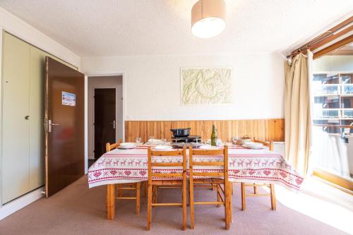 une salle à manger avec une table et des chaises dans l'établissement Miquey - Appt proche station de ski, à Villarembert