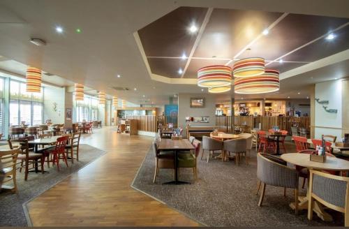 un comedor con mesas y sillas y un restaurante en Impeccable 3- bed luxury Lodge in Camber Sands, en Rye