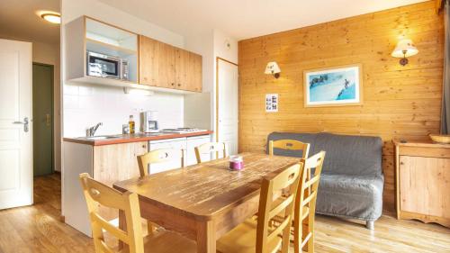 une cuisine et une salle à manger avec une table et des chaises en bois dans l'établissement V du Bachat Silenes B11 Appt belle vue 4 6 pers, à Chamrousse