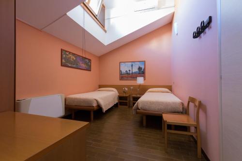 Habitación hospitalaria con 2 camas y mesa en Antica Trattoria dell'Uva, en Monza