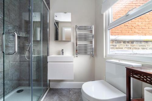 ein Bad mit einer Dusche, einem WC und einem Waschbecken in der Unterkunft Stylish 3 BDR apartment wfree parking and garden in Kingston upon Thames