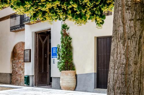 a building with a door and a tree at YIT Abentofail in Guadix