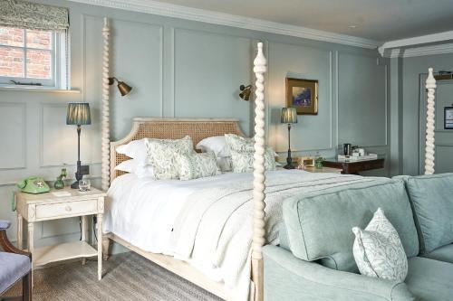 1 dormitorio con cama con dosel y sofá en Stanwell House en Lymington