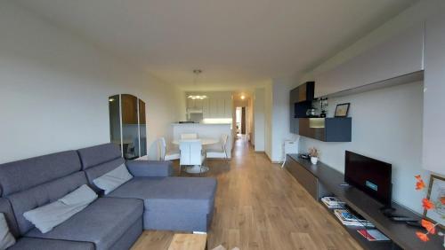 ein Wohnzimmer mit einem Sofa und einem Tisch in der Unterkunft Residentie Koksijde promenade in Koksijde
