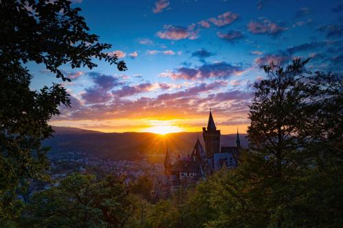a sunset over a city with a church at TraumFeWo Palais #Innenstadt #Garten #Netflix von Harztraveler in Wernigerode