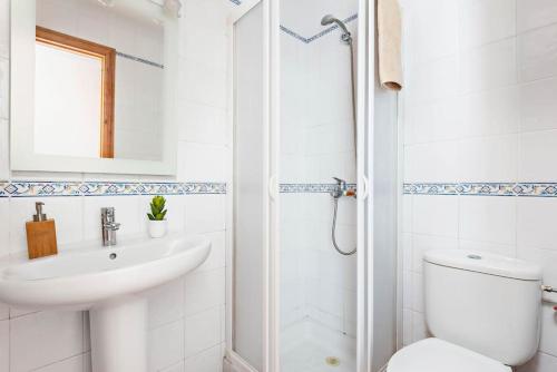 a white bathroom with a toilet and a sink at Villa María in Son Bou