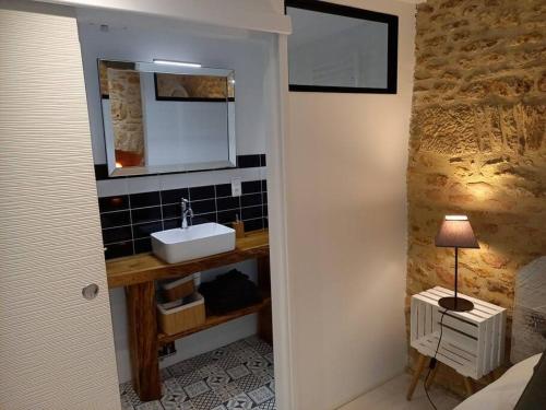 une salle de bain avec un lavabo et un miroir dans l'établissement Gîte Talia, à Saint-Crépin-et-Carlucet