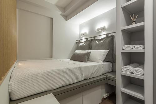 ein kleines Schlafzimmer mit einem Bett und einigen Handtüchern in der Unterkunft Athens Gateaway Next To Kallimarmaro And Acropolis in Athen