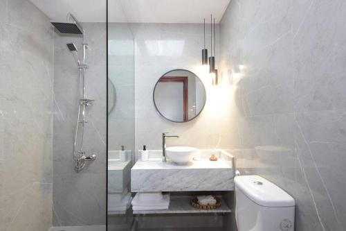 een badkamer met een wastafel, een spiegel en een toilet bij Skyline Views 1 Bedroom Apartment Lake Facing in Dubai