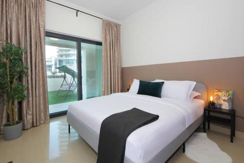 een slaapkamer met een groot wit bed en een balkon bij Skyline Views 1 Bedroom Apartment Lake Facing in Dubai