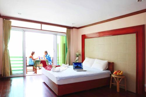 a bedroom with a bed with a laptop on it at El Nido Beach Hotel in El Nido